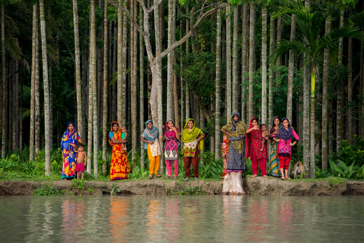 Women watch the MAF float plane in Bangladesh.